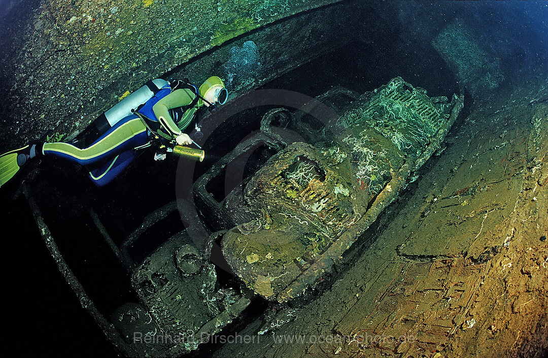 Scuba diver diving in the Umbria shipwreck, Military cars