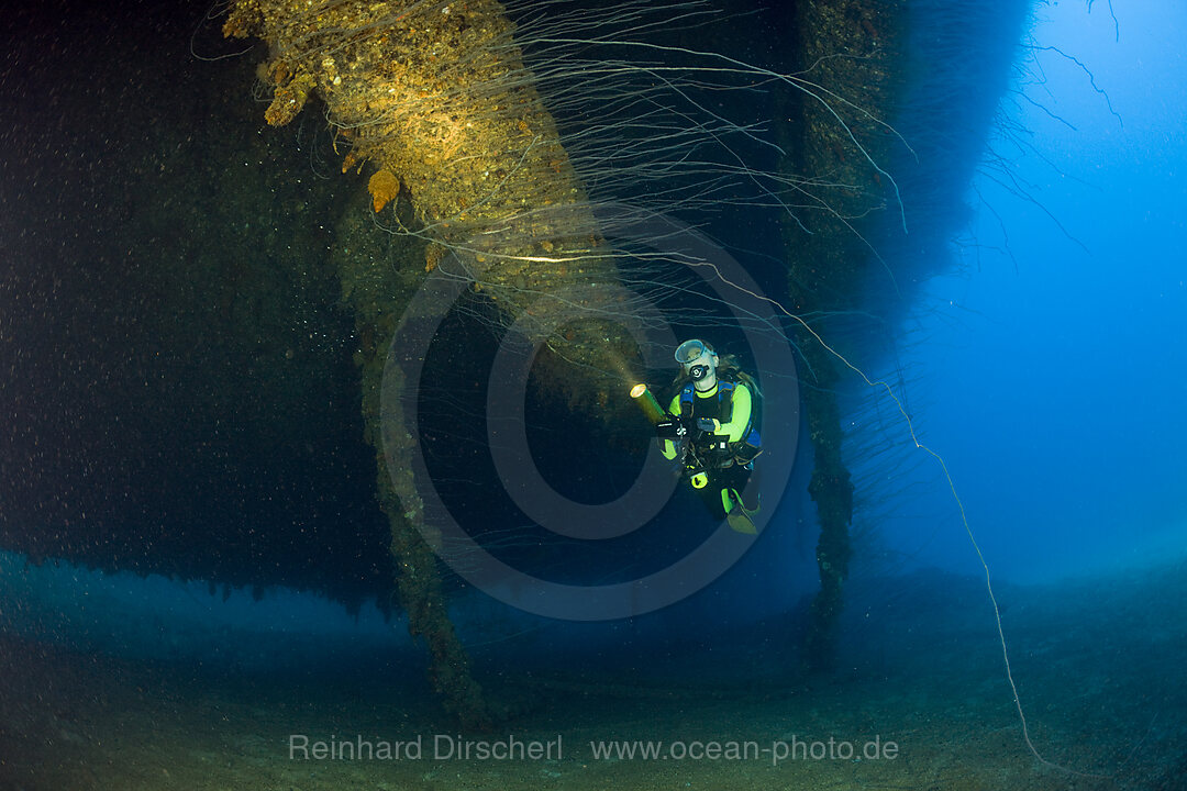 Taucher am massiven 16-Zoll 45 Kaliber Geschuetz unter der HIJMS Nagato, Bikini Atoll, Mikronesien, Pazifik, Marschallinseln