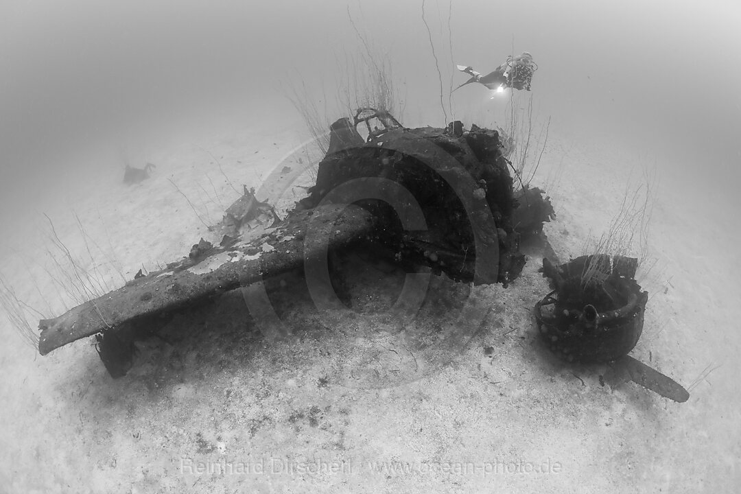 Taucher ueber Kampfflugzeug neben der USS Saratoga