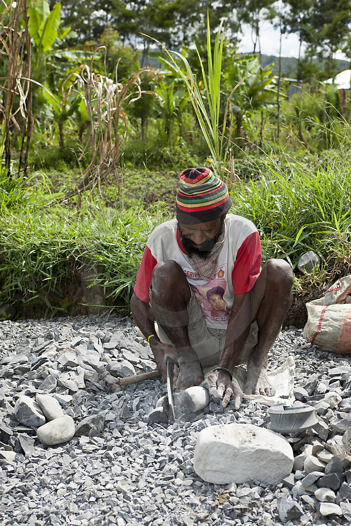 Dani Mann klopf Steine, Baliem Valley, West Papua, Indonesien