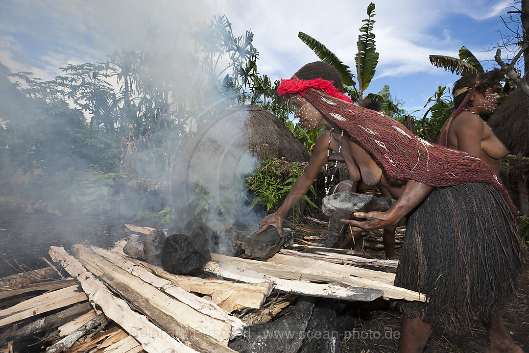 Dani Tribe heat Stones in Fire for Earth Oven