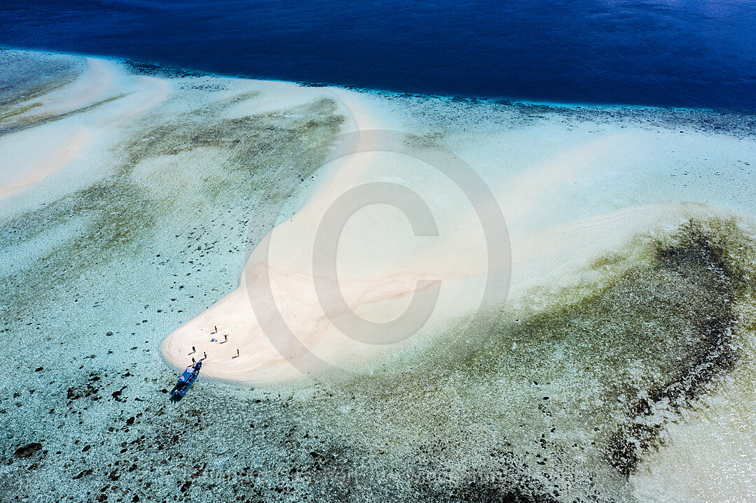 Tourists having fun on sand bank, Raja Ampat, West Papua, Indonesia