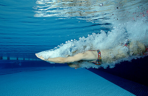 Frau springt in Schwimmbecken