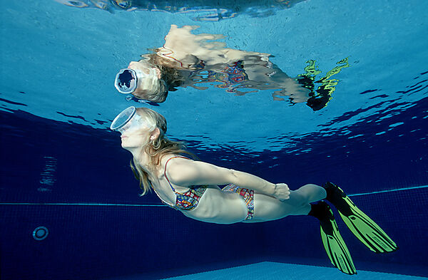 Frau taucht im Schwimmbecken