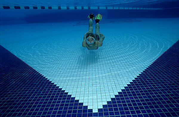 Frau taucht im Schwimmbecken