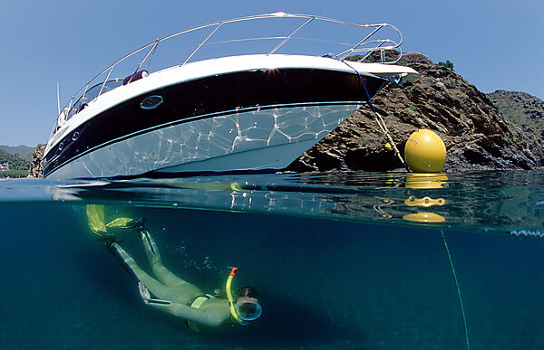Skin diving in front of a yacht, split image