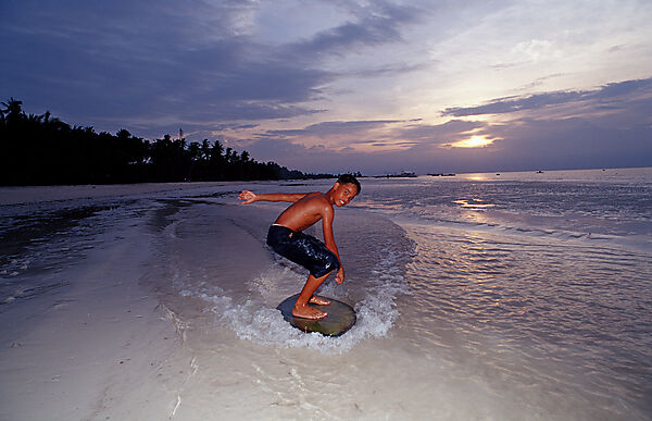 Kinder surfen am Strand