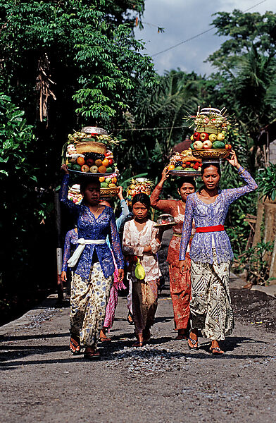 Frauen mit Opfergaben gehen zum Hindu Tempel Ubud