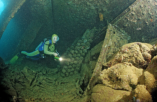 Scuba diver diving in the Umbria shipwreck, Bombs