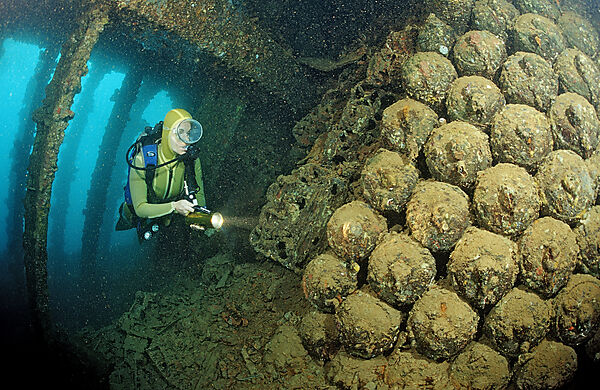 Scuba diver diving in the Umbria shipwreck, Bombs