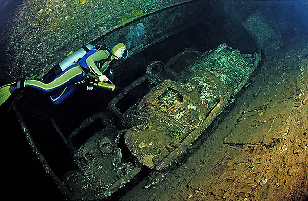 Scuba diver diving in the Umbria shipwreck, Military cars