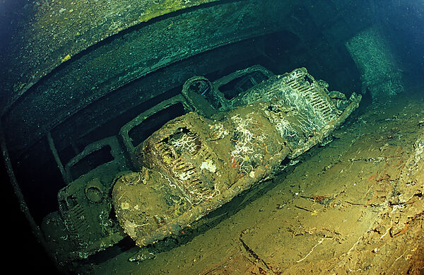 Scuba diver diving in the Umbria shipwreck, Military cars