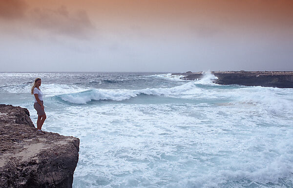 Woman and stormy coast