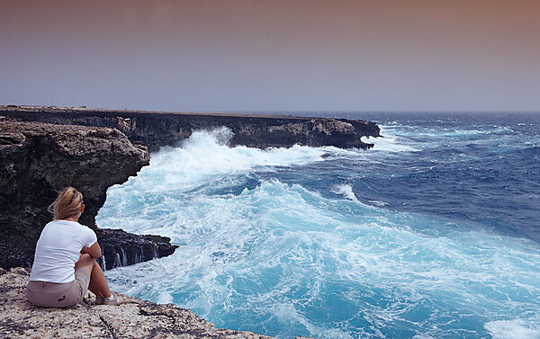 Woman and stormy coast