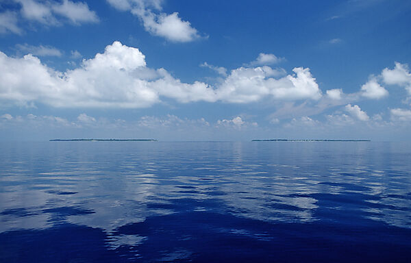 Wolken ueber spiegelglattem Meer