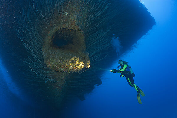Taucher an einer Ankerkluese am Bug der USS Saratoga
