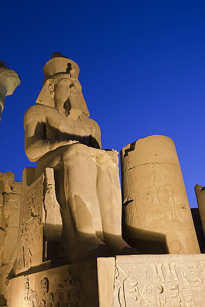 Beleuchtete Sitzstatue des Ramses II. im Saeulenhof von Luxor-Tempel