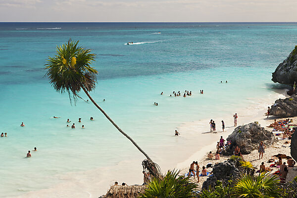 Touristen am Strand vor den Maya Ruinen von Tulum
