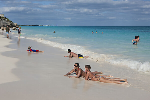 Touristen am Strand vor den Maya Ruinen von Tulum