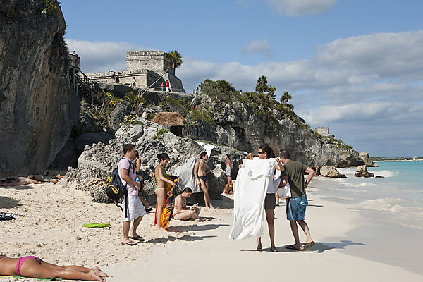 Touristen am Strand vor den Maya Ruinen von Tulum