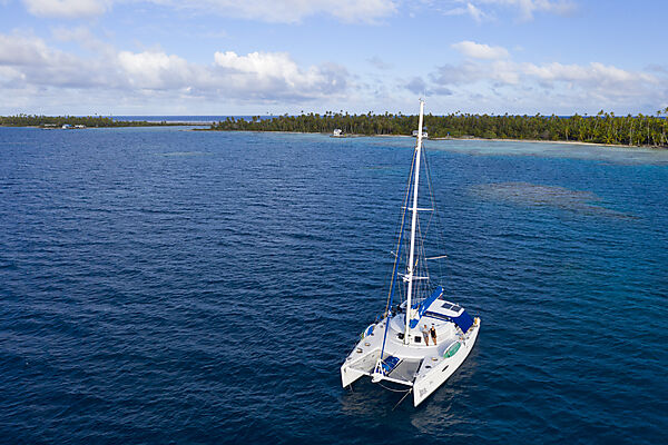 Katamaran vor Ahe Atoll, Tuamotu Archipel, Franzoesisch Polynesien